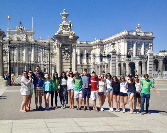 Students stand in a line in front of the Royal Palace in Madrid, Spain