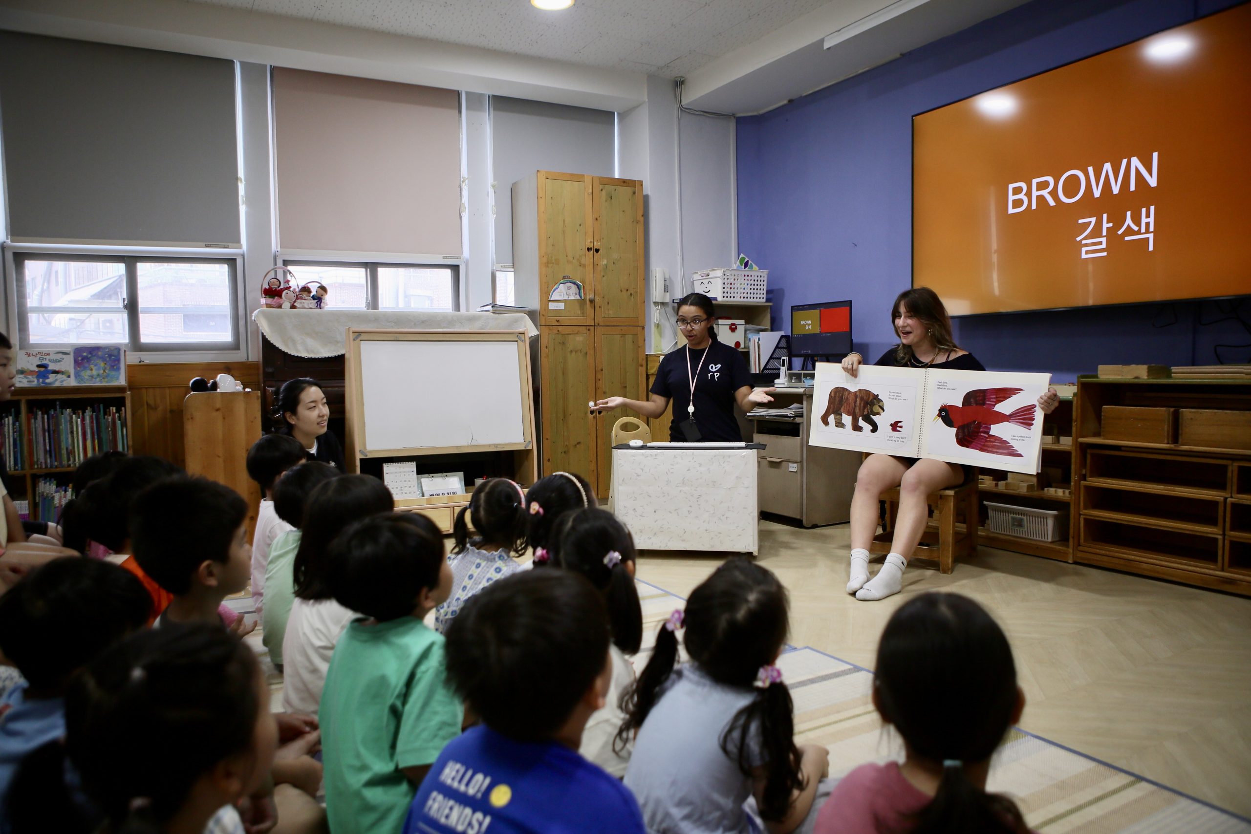 Student travel vs college: a group of children sitting in a classroom following to student travel volunteers teaching the class.