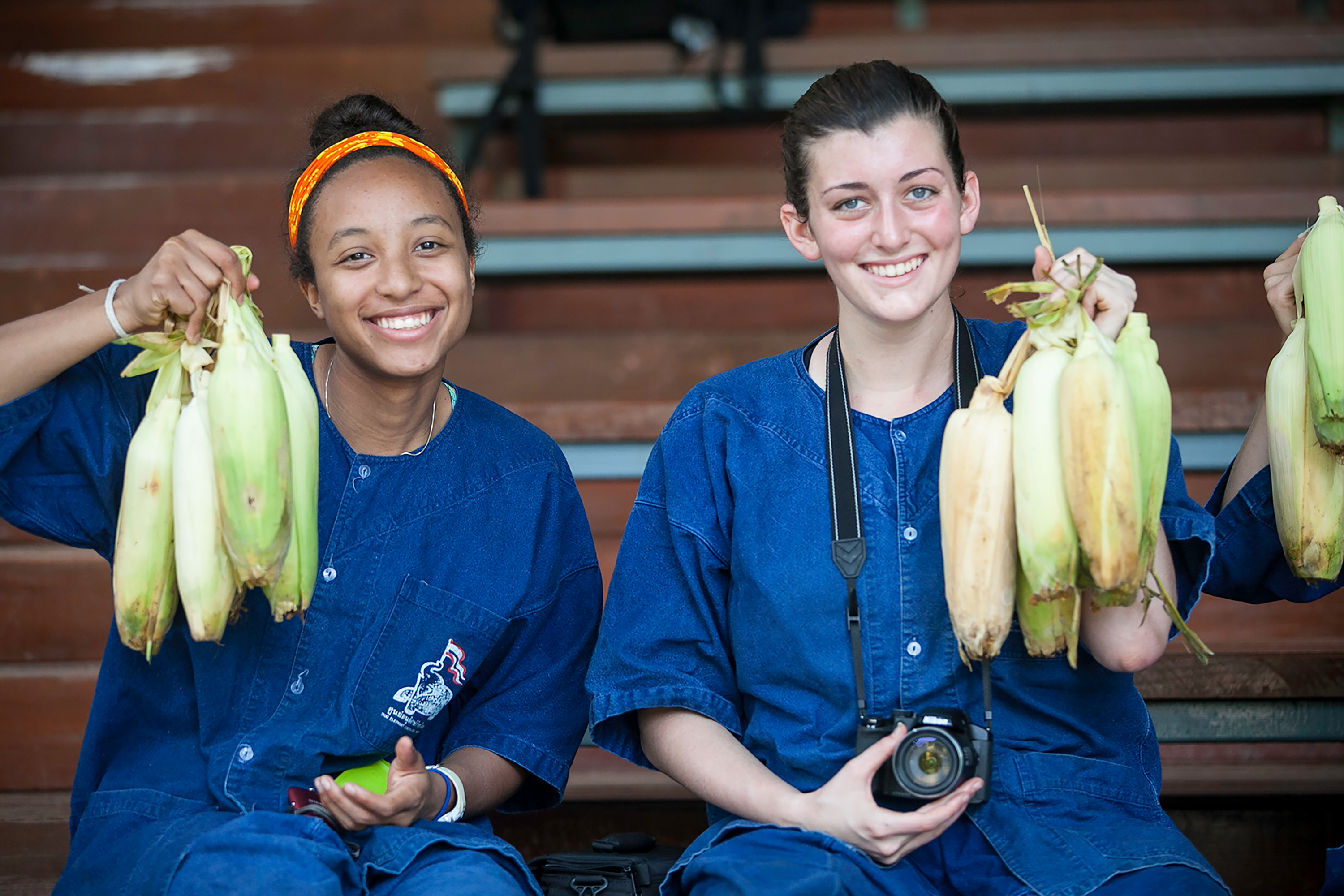 Students smiling at the camera while holding bananas in Thailand