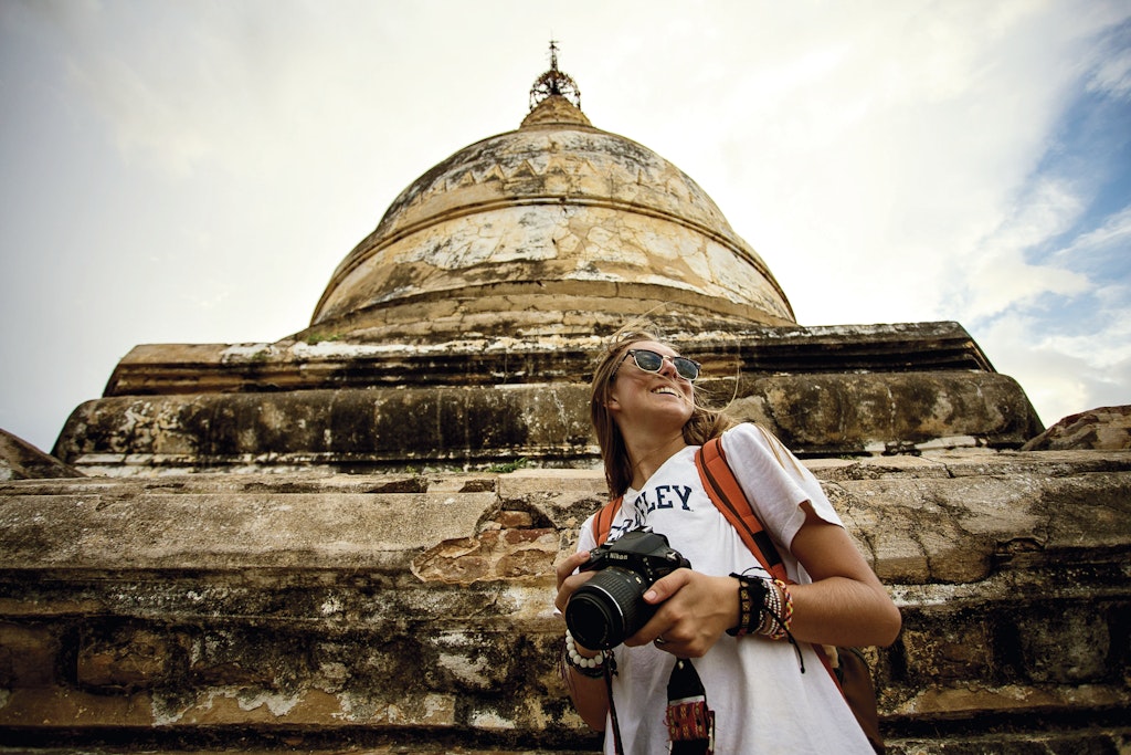 A photographer standing in front of an a temple building. 