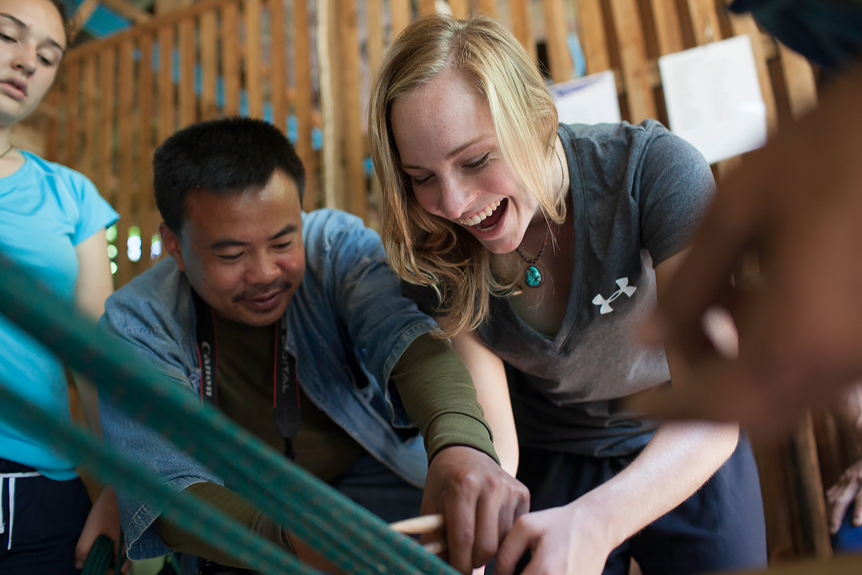 Instructor in Thailand teaching student how to do arts and craft project.