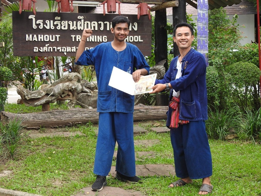 Two people are celebrating a student receiving a scholarship in Thailand.