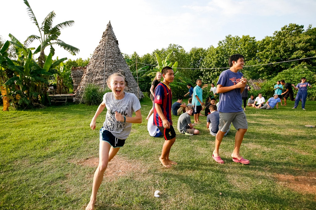 Kids run in the green field.