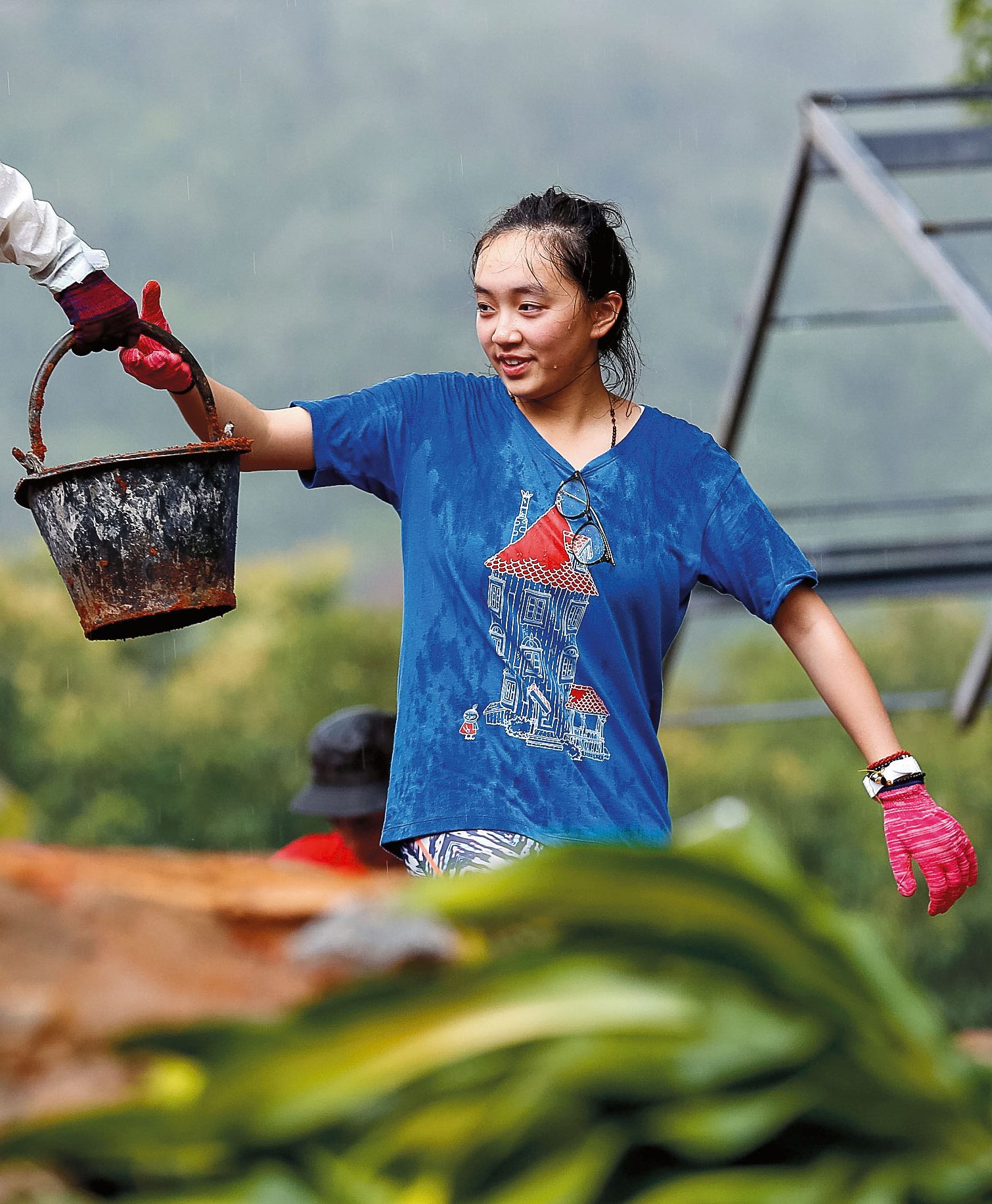Students pass a bucket during outdoor service work