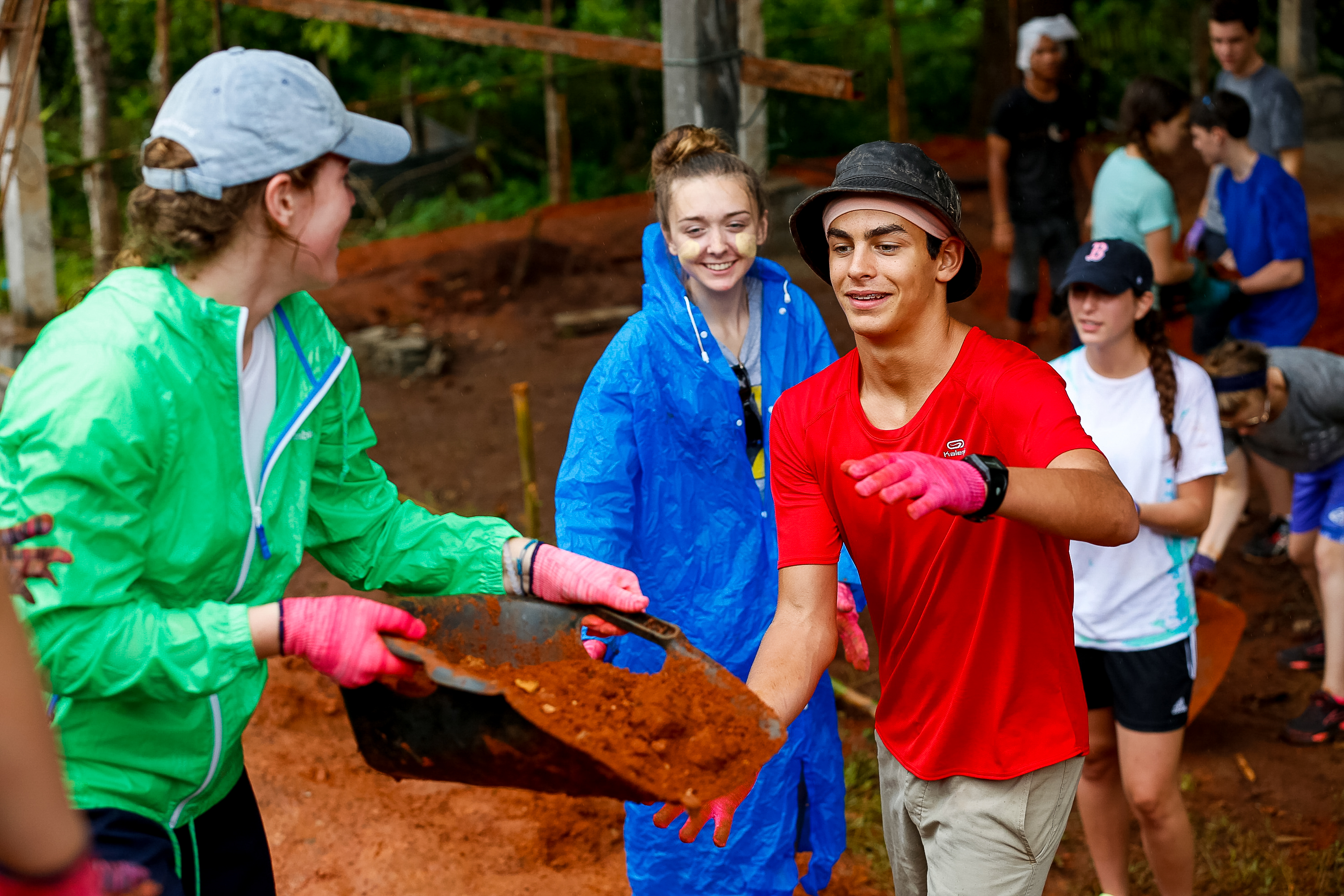 Students carry a tray of soil during a reforestation project