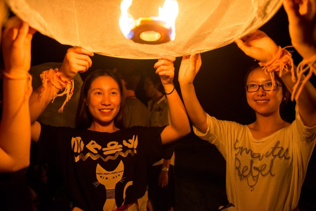 A group of people set a balloon in the air.