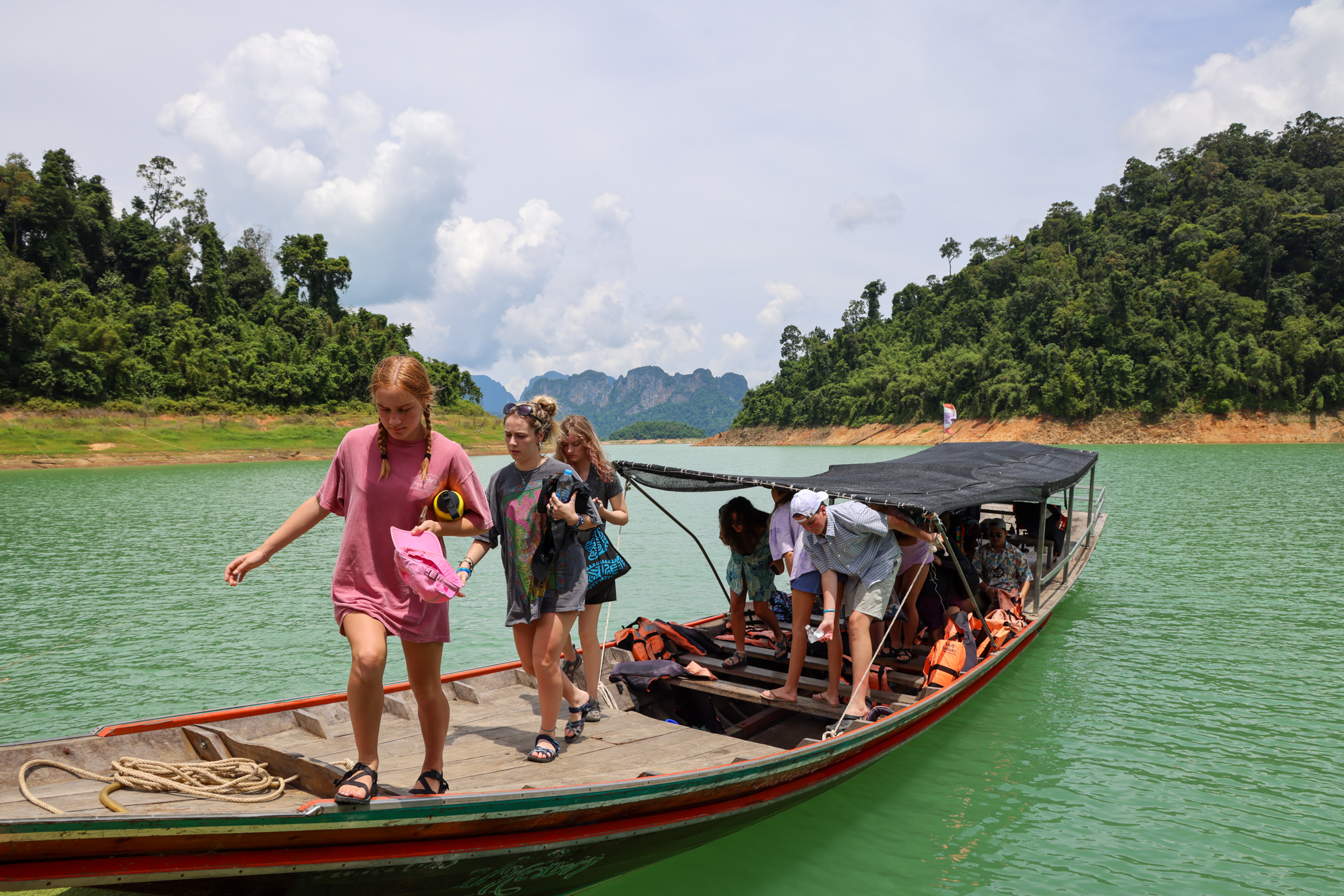 Students standing on top of boat in Thailand.