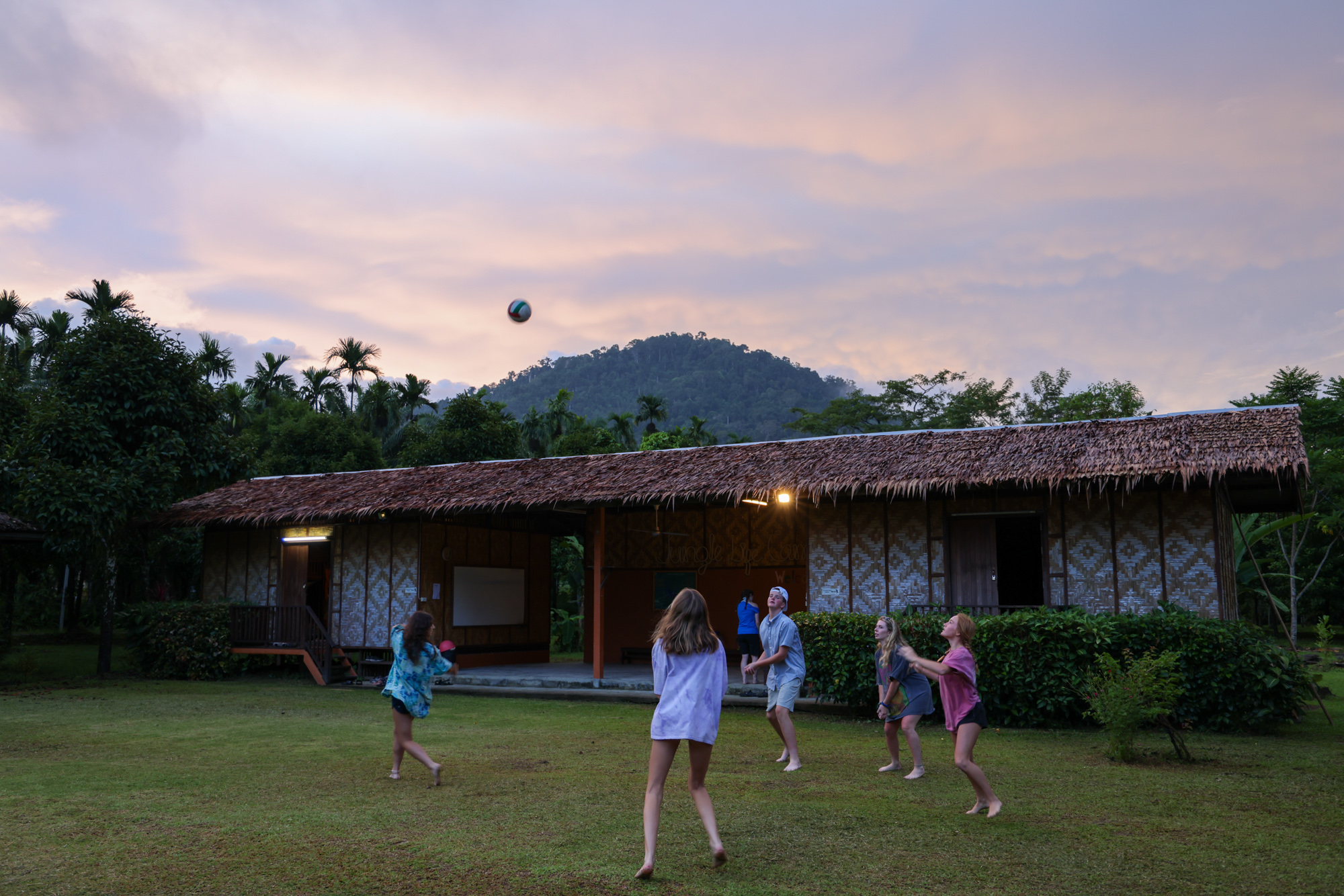 Students playing volleyball outside accomodation in Thailand.