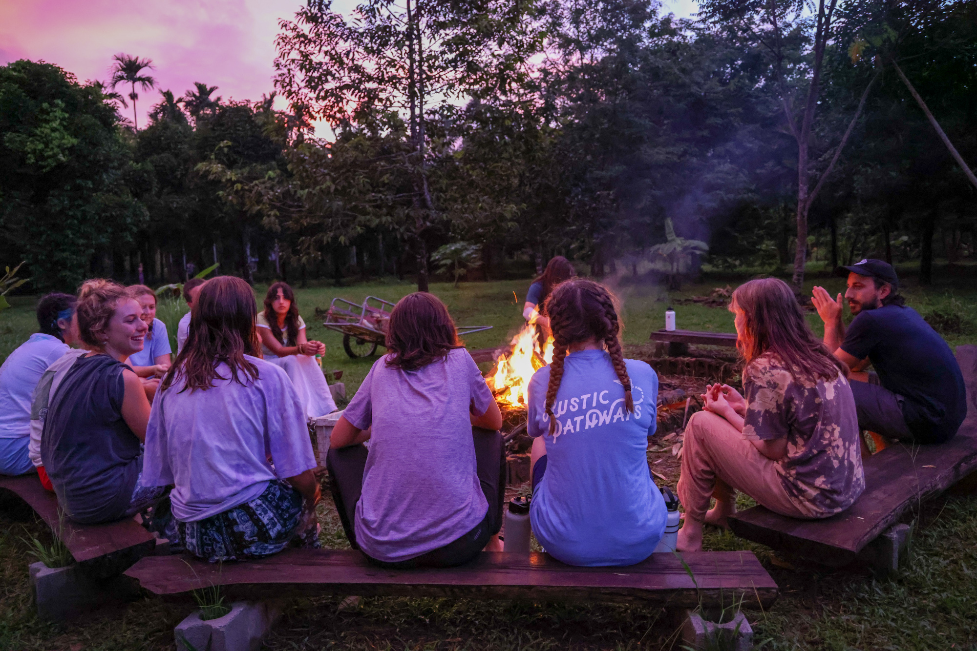 Students gathered around a campfire at night in Thailand.