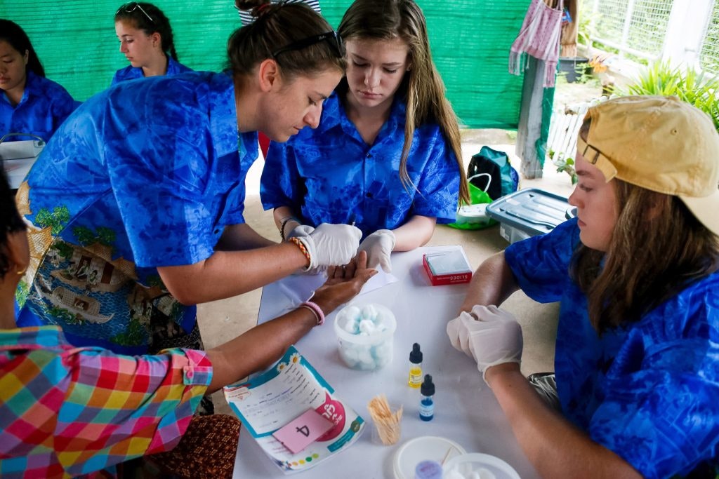 Student travelers volunteering on a public health initiative during a medical teen tour.
