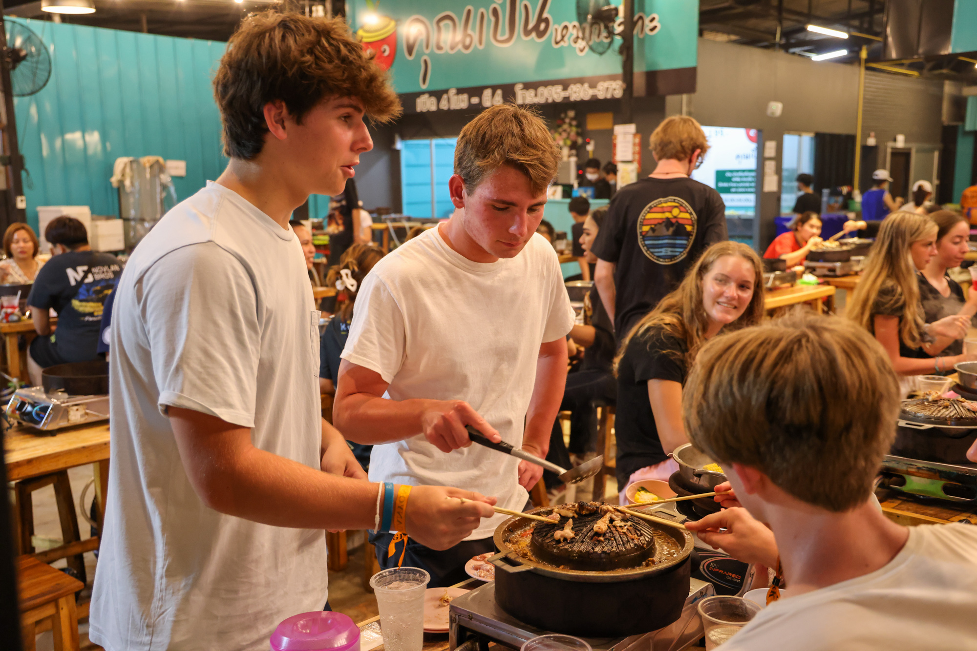Students in Thailand cooking food together.