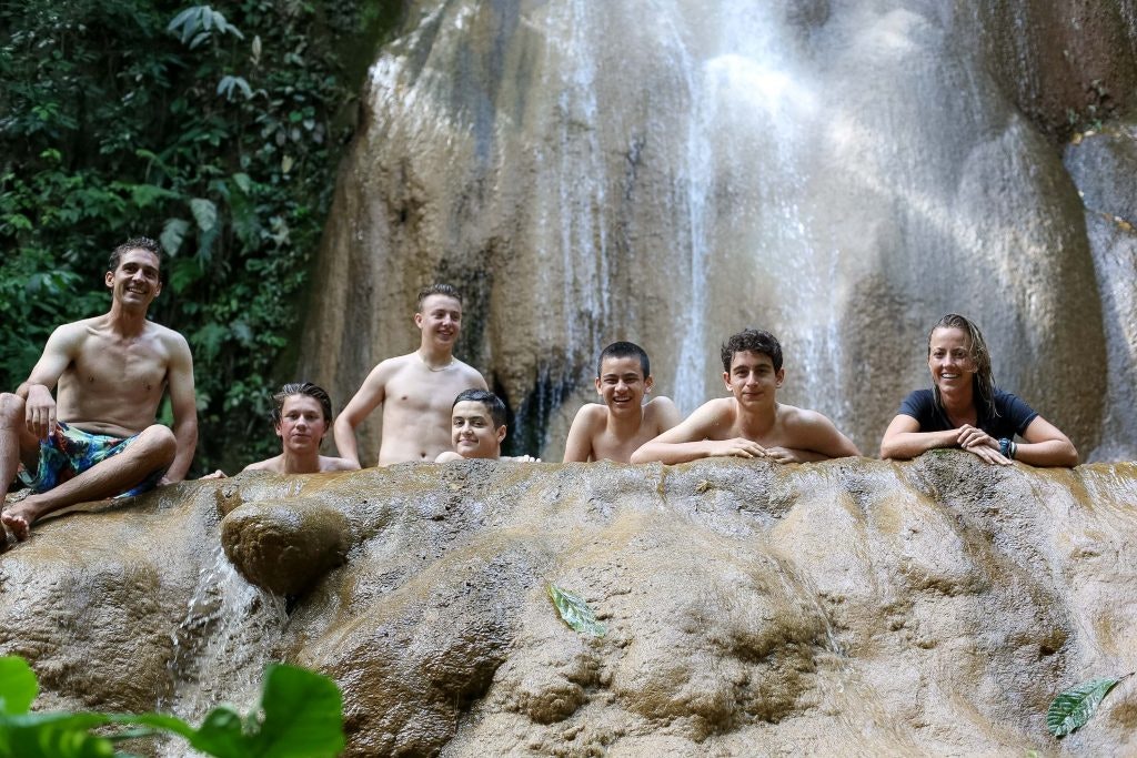 Teen tour to Thailand participants cool down in a sticky waterfall.