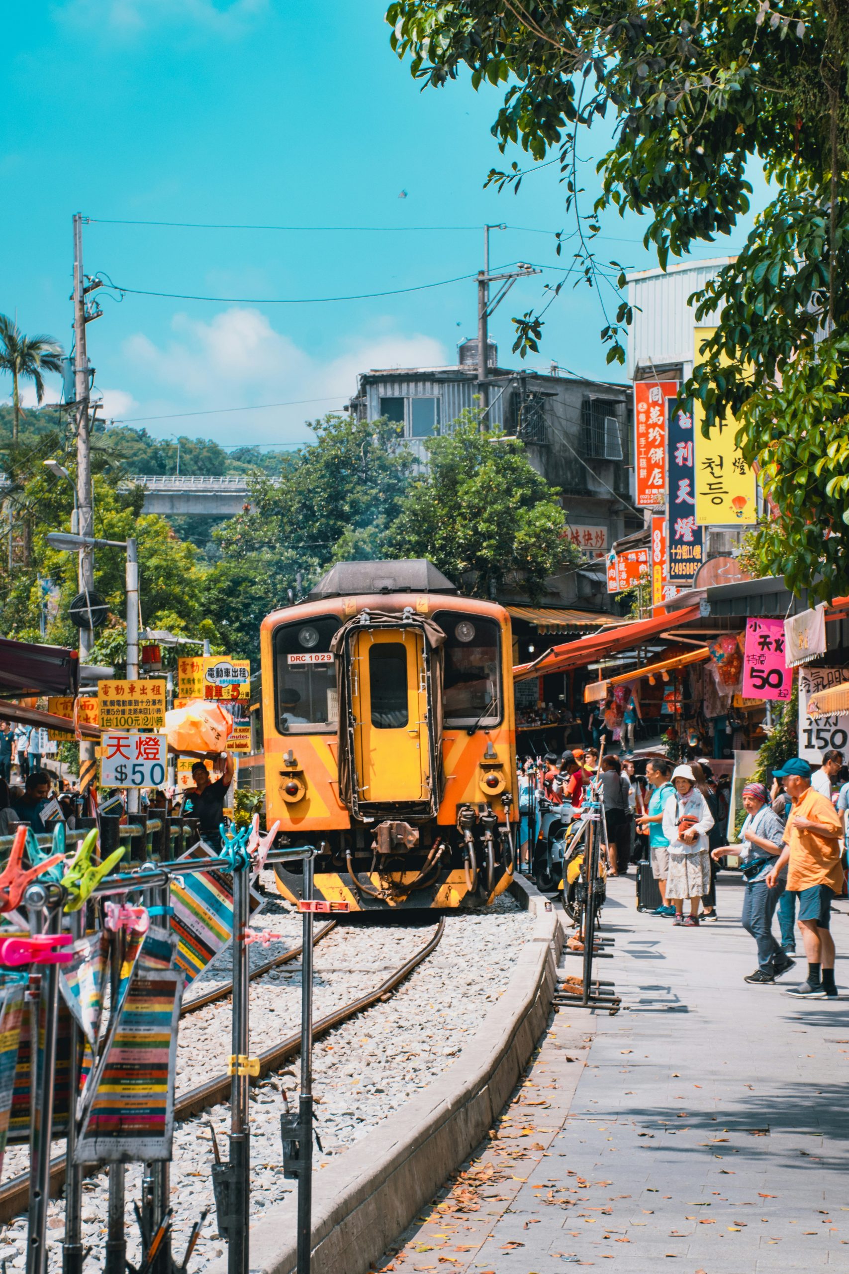 A Pingxi Line train running along Shifen Old Street, between shops selling sky lanterns.