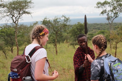 Volunteer in Africa students interact with a local Masaai man during a cultural exchange on a volunteer abroad trip to Tanzania
