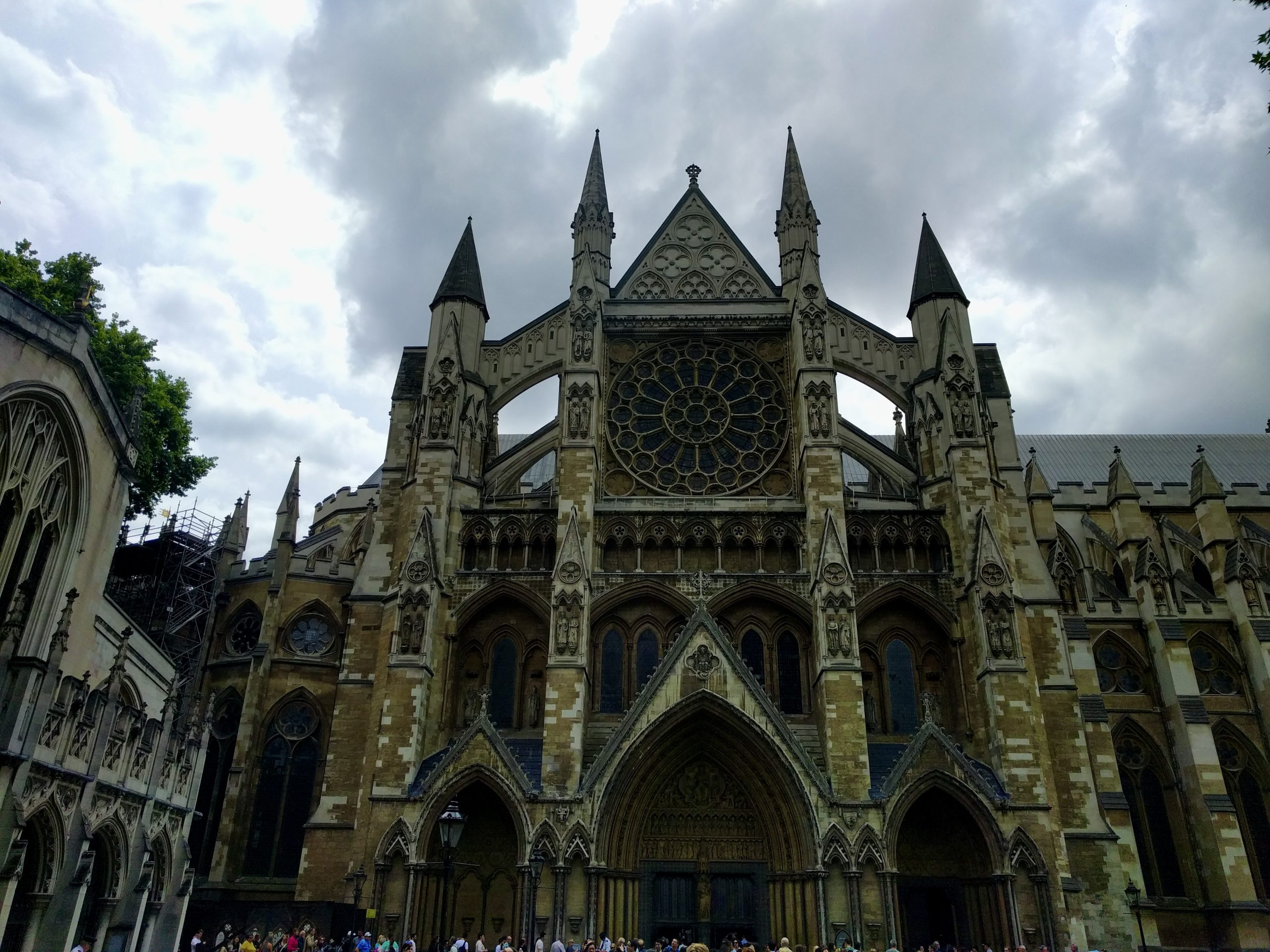 Westminster Abbey's Gothic facade and rose window rise under a cloudy sky