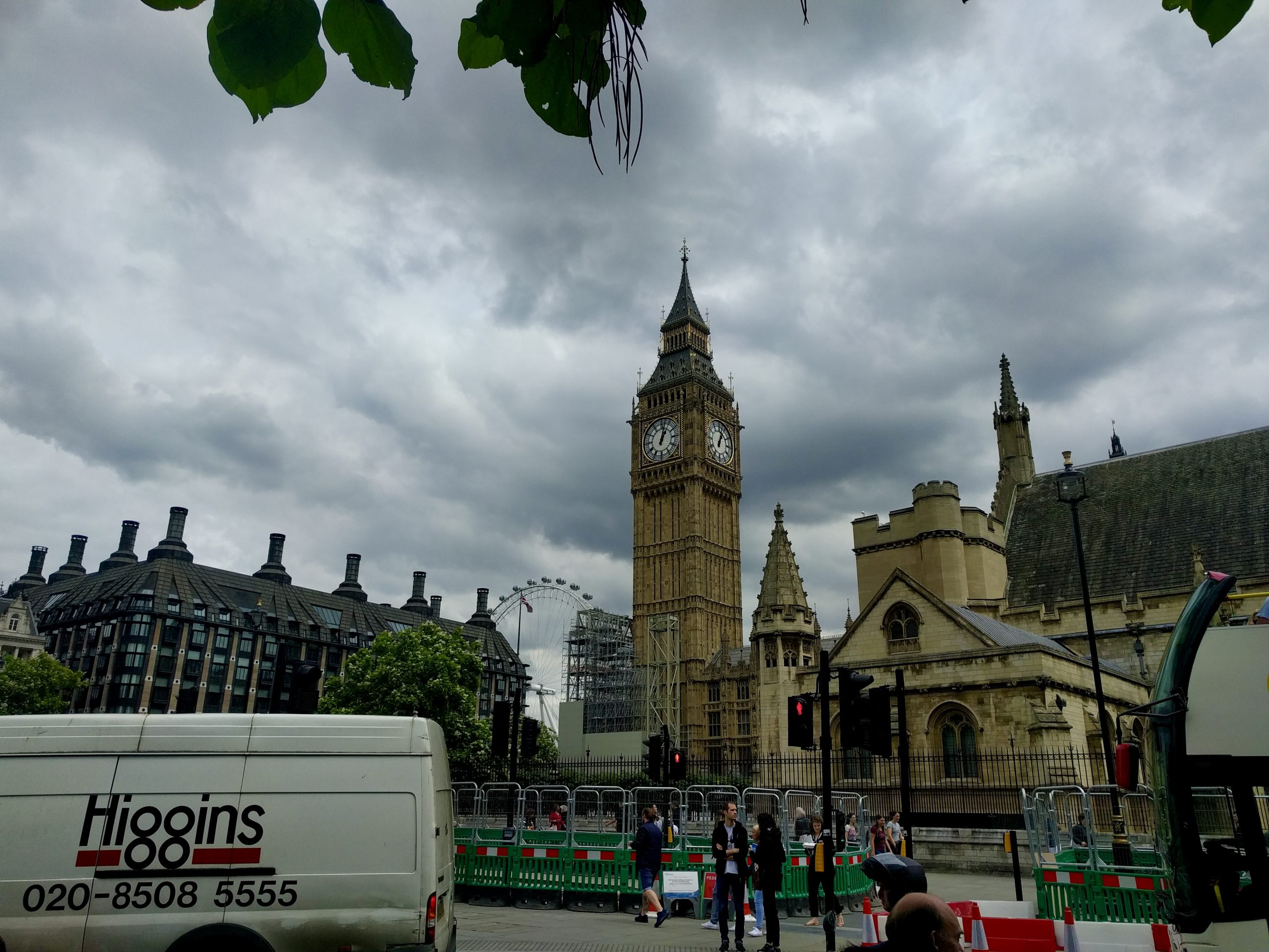 Big Ben clock tower rises above Parliament Square under a cloudy sky