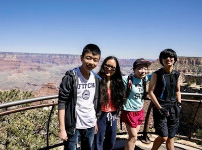 Students taking a photo with the grand canyon behind them on a summer teen tour in the USA.