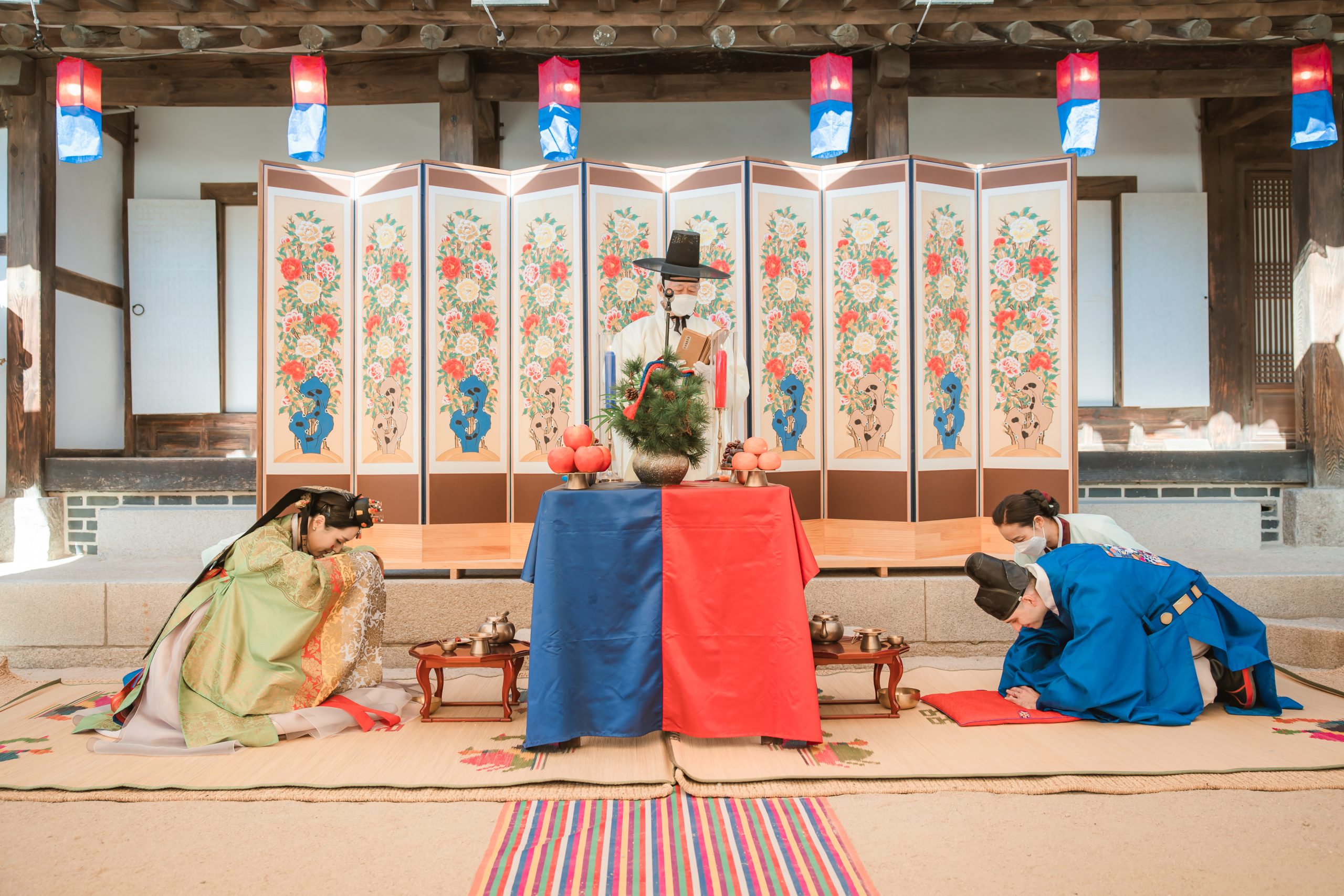 A couple bowing during to each other during a Traditional Korean wedding ceremony.