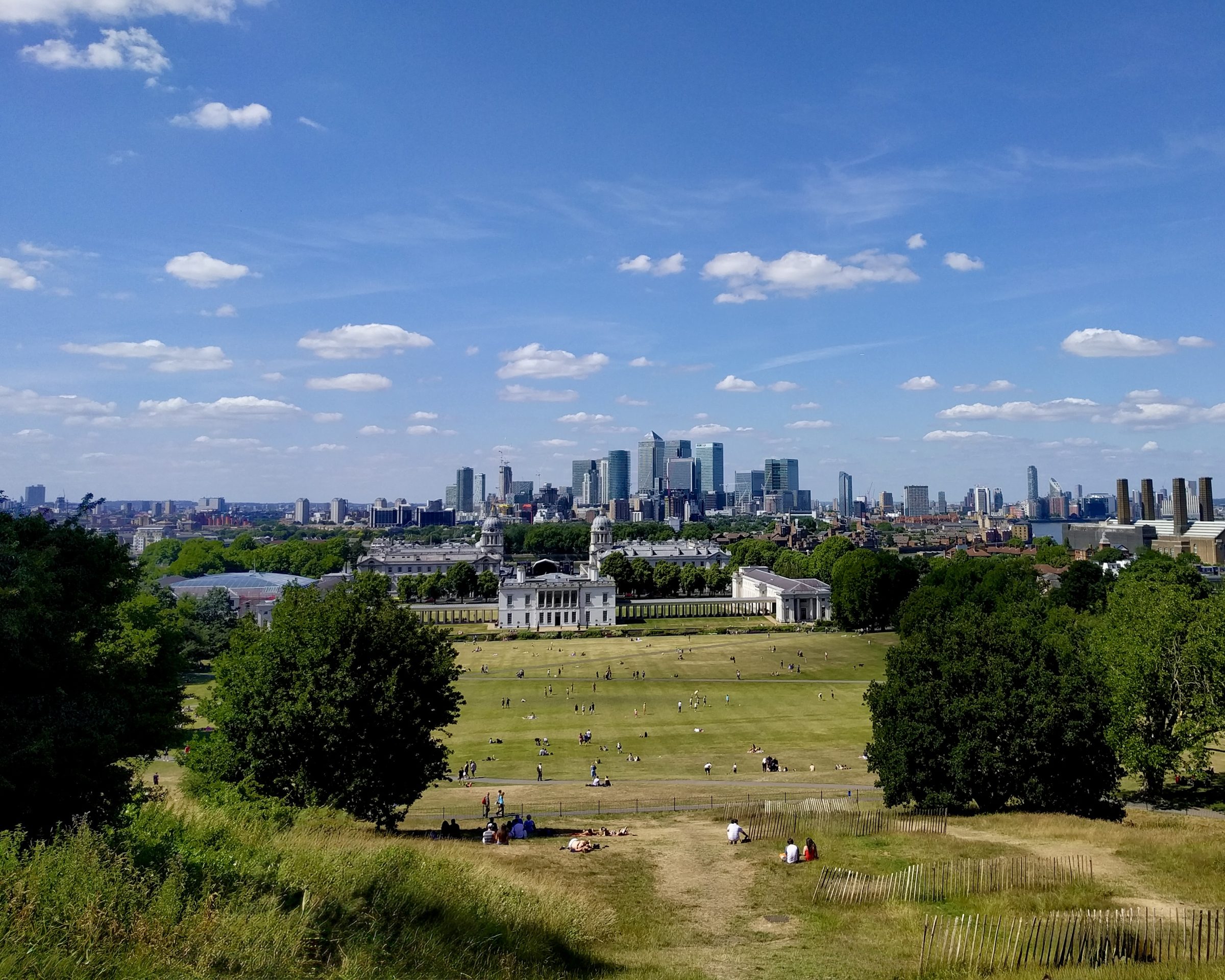The lawns of Greenwich Park above the Old Royal Naval College, with the Canary Wharf skyline behind