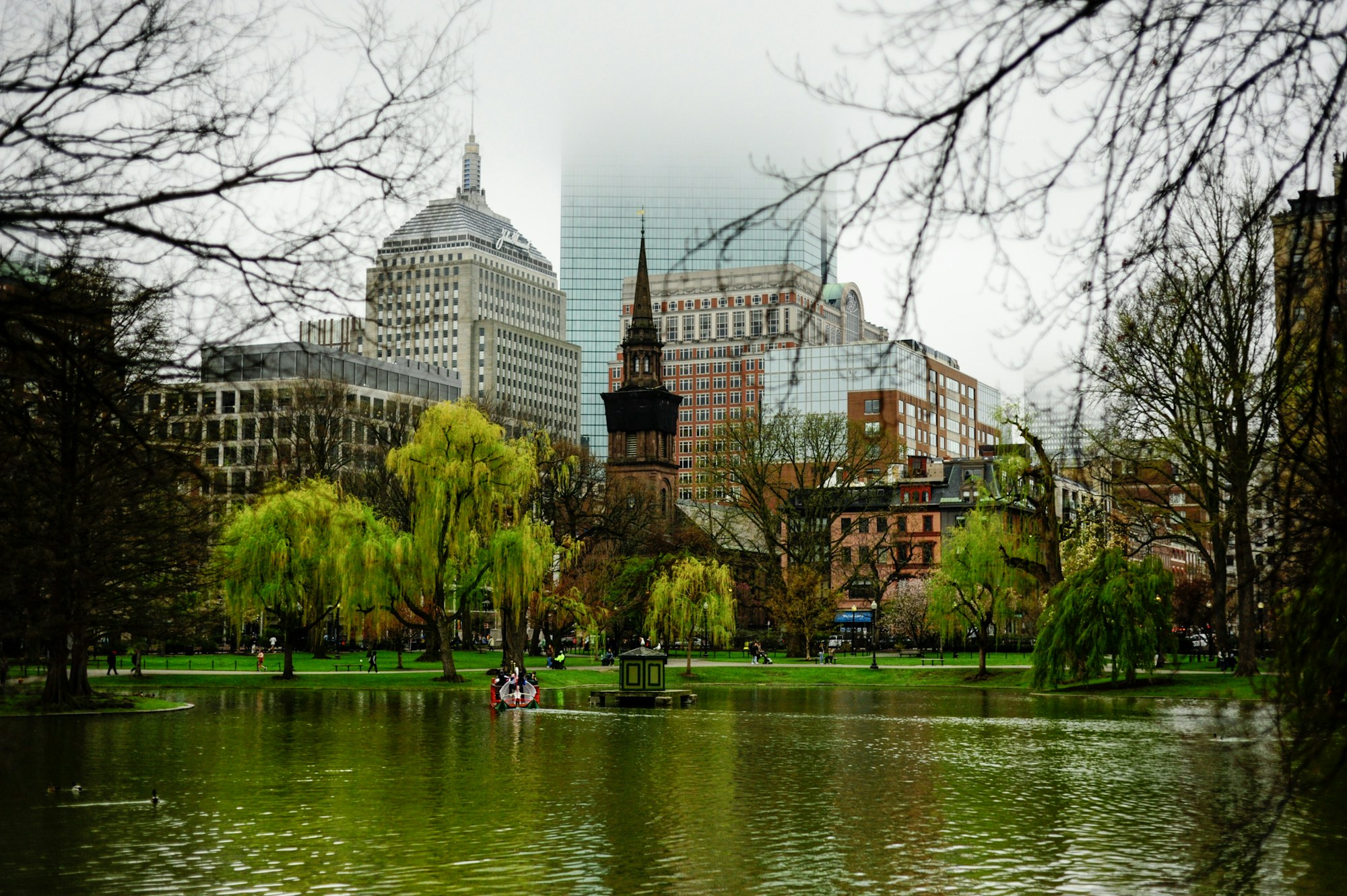 The lagoon in the Boston Public Garden with Back Bay rooftops behind it.