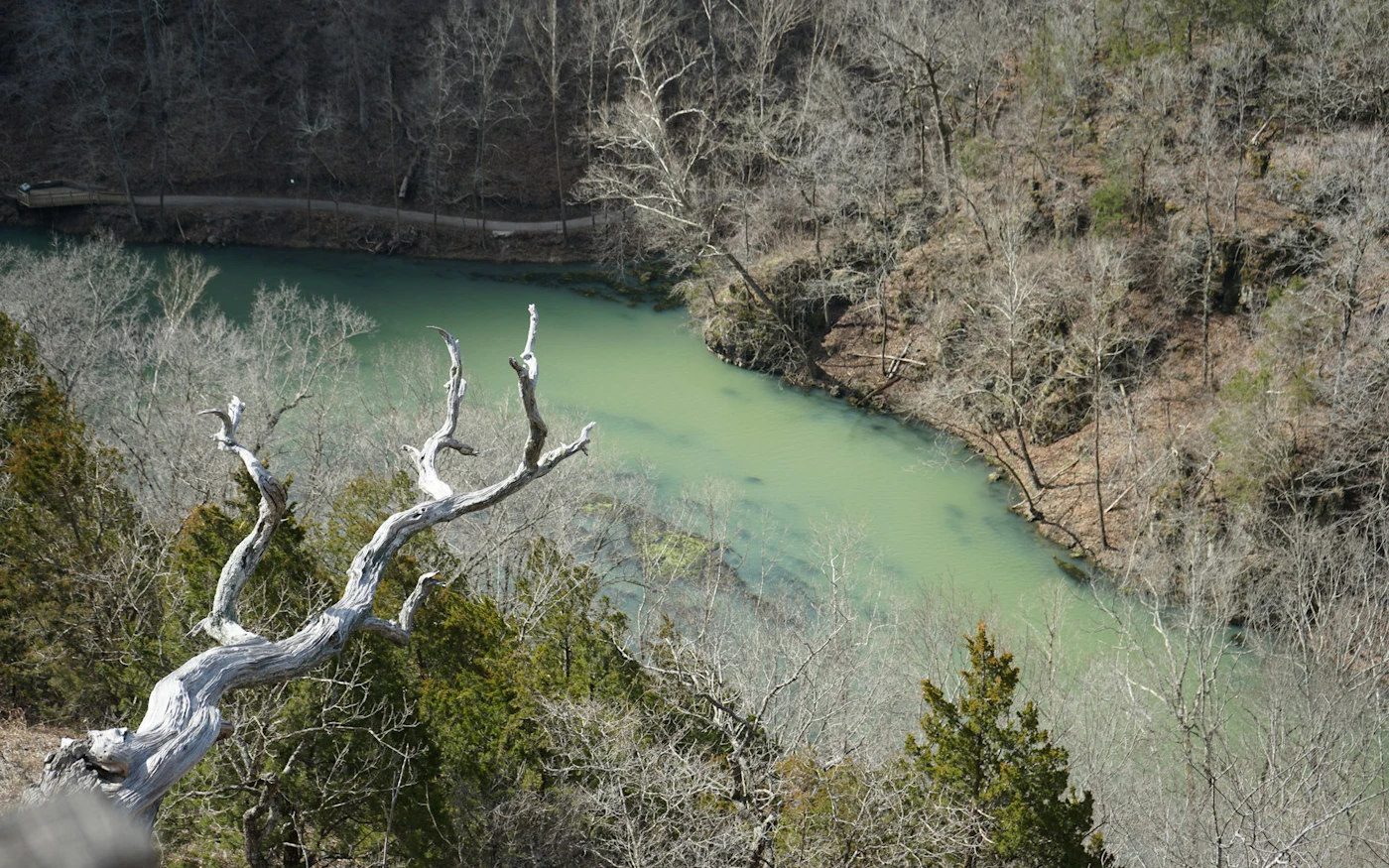 A clear Ozark river beneath a limestone bluff.