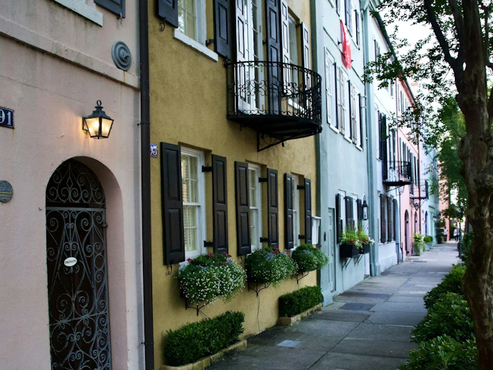 A lamp-lit street of pastel houses in historic Charleston.