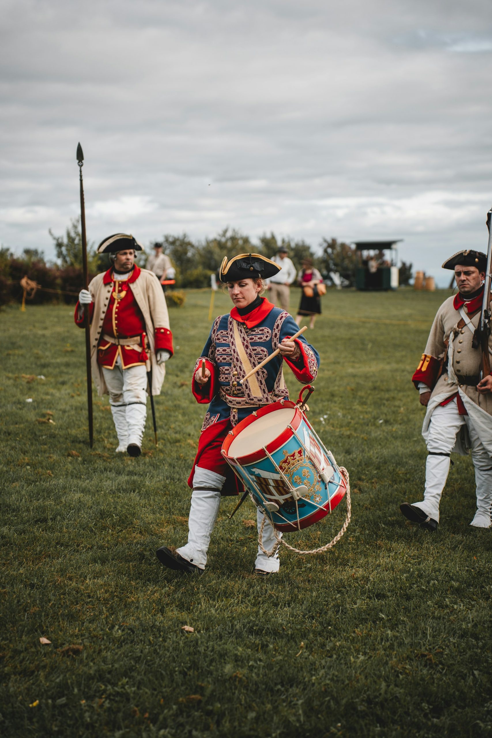 A fife and drum corps in red coats on the green at Colonial Williamsburg.