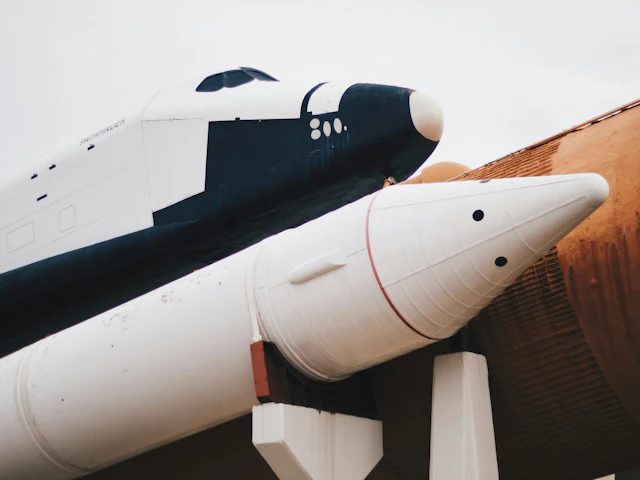 A rocket on display against an overcast sky.