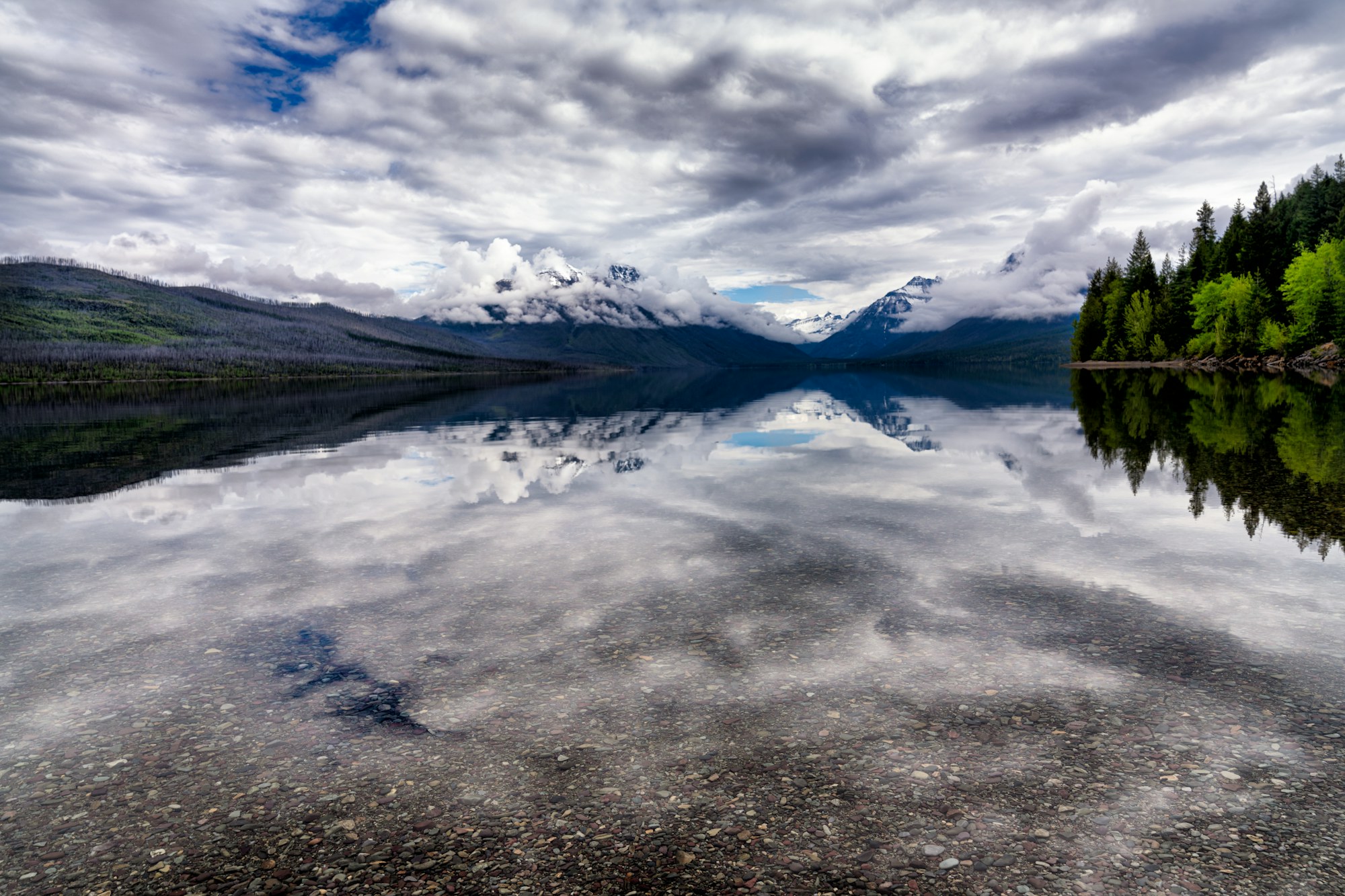 Still water reflecting the peaks at Lake McDonald, Glacier National Park.
