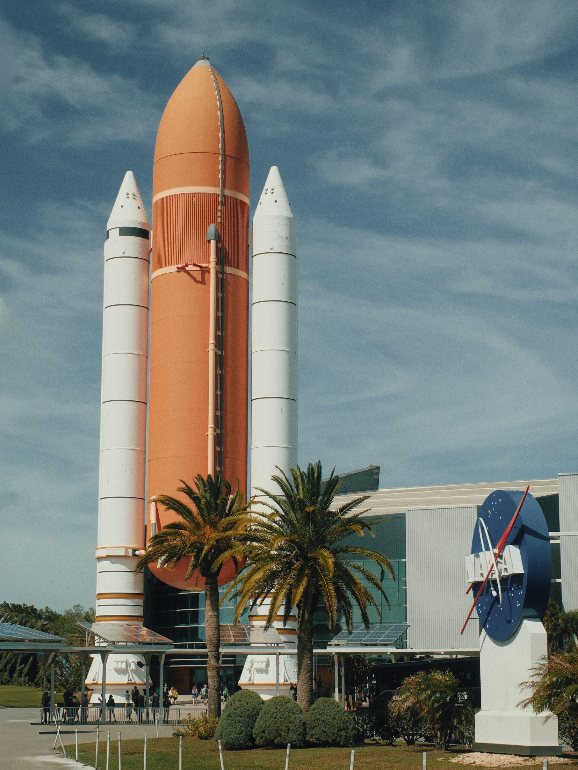 Solid rocket boosters standing above the palms at Kennedy Space Center.