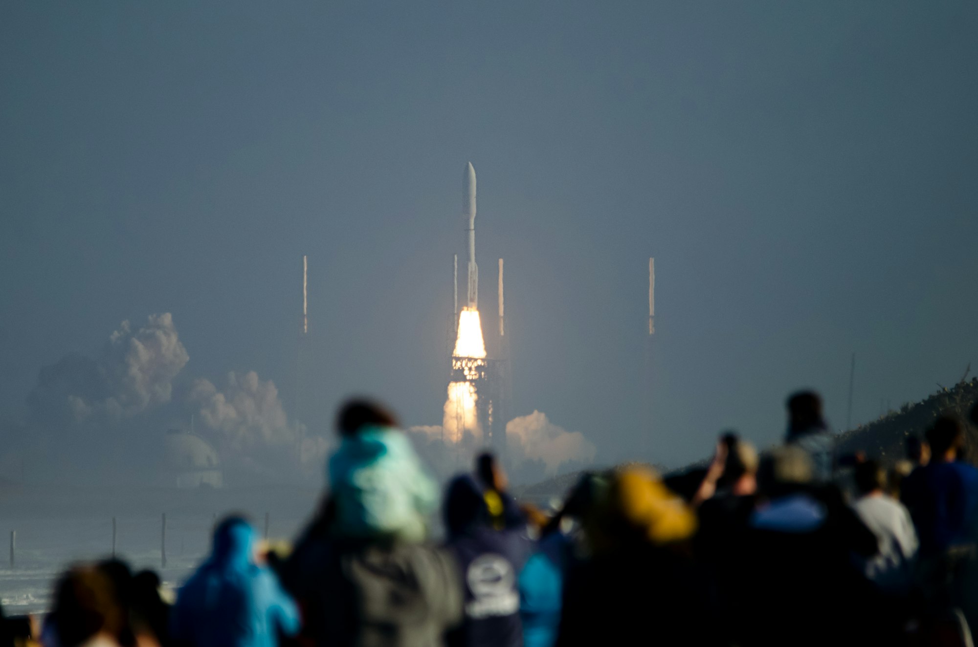 A crowd watching a rocket launch from the Space Coast.