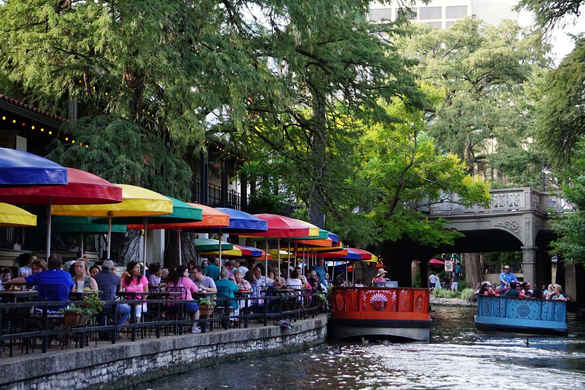 Cafés and landscaped paths beside the San Antonio River Walk.