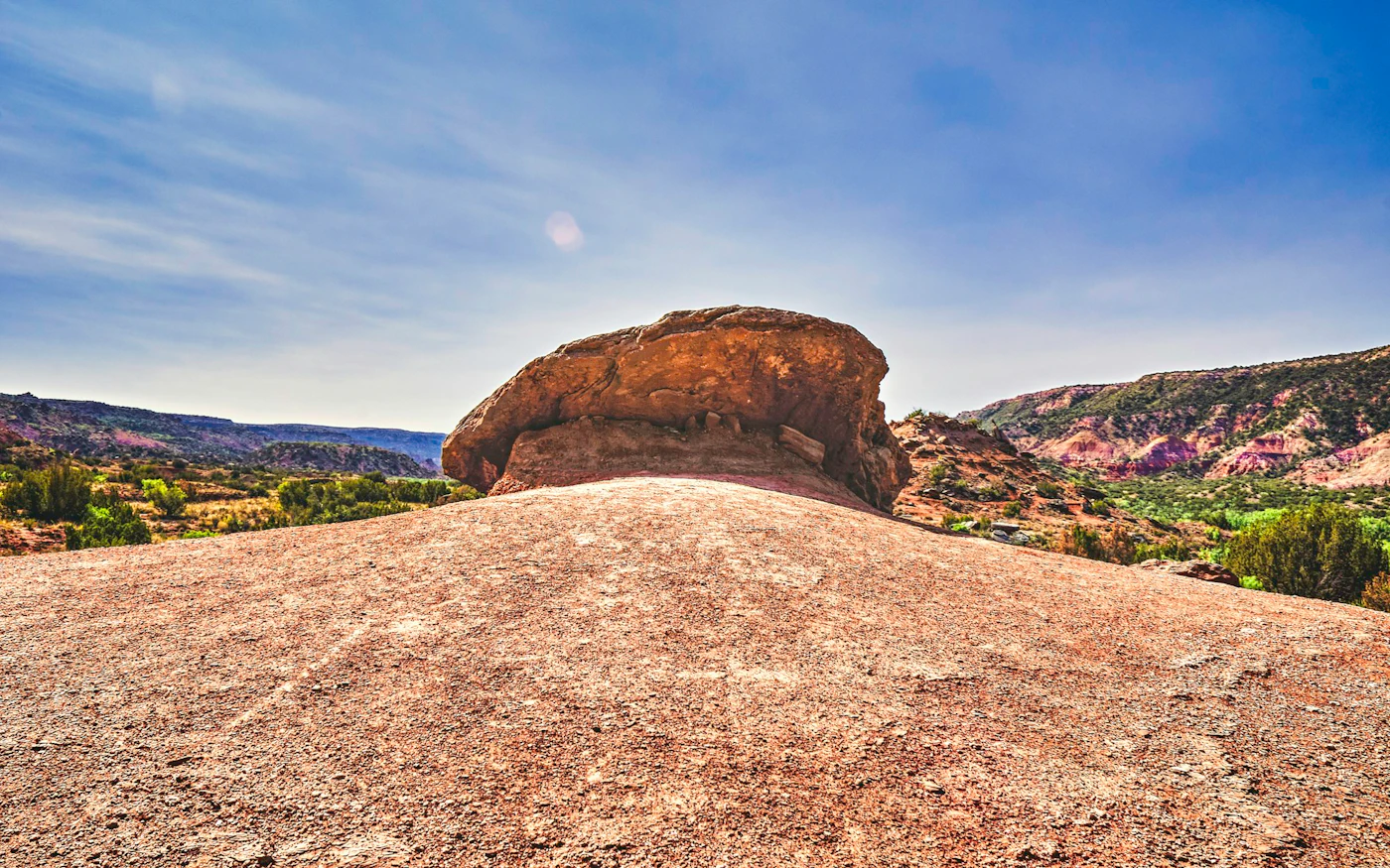 A weathered granite boulder and the surrounding landscape at Enchanted Rock.
