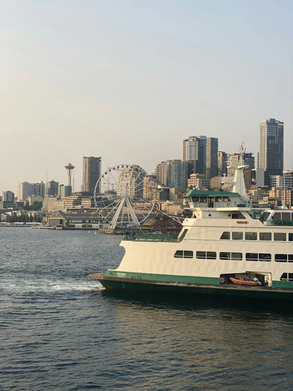 A Washington State ferry crossing Elliott Bay beside the Seattle waterfront.