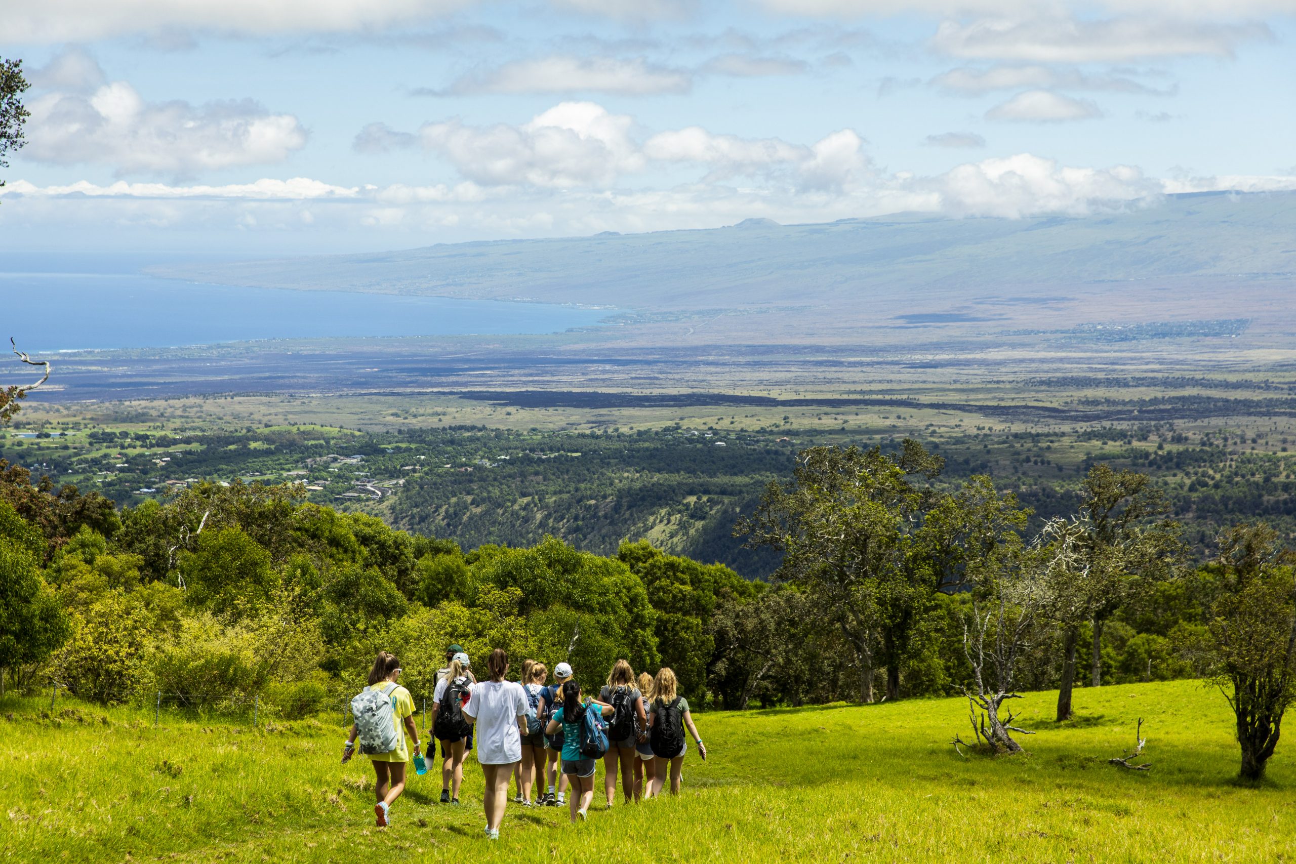 Photo of students going down a hill with a view of the other hills in the background.