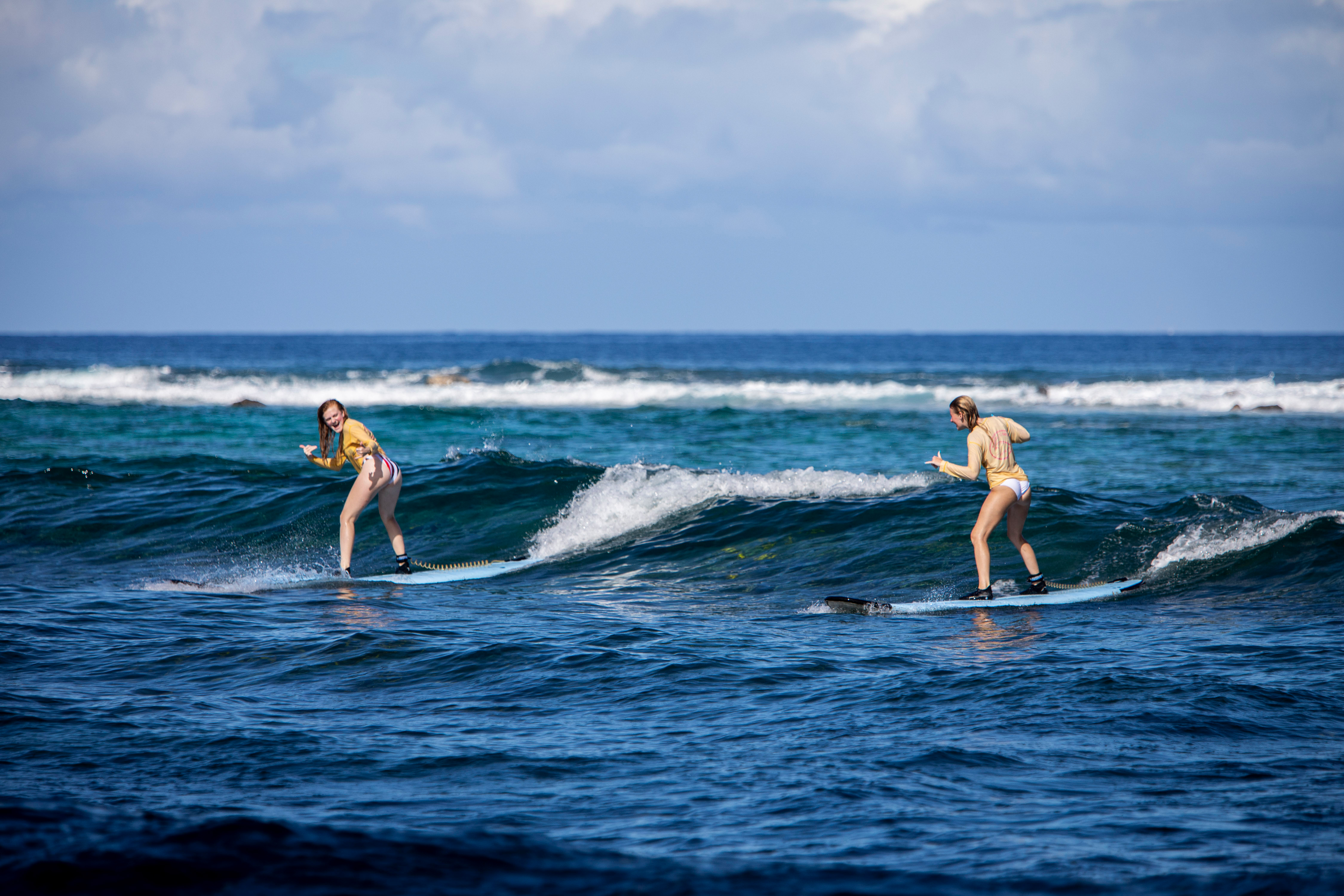 Students ride waves on surfboards in Hawaii