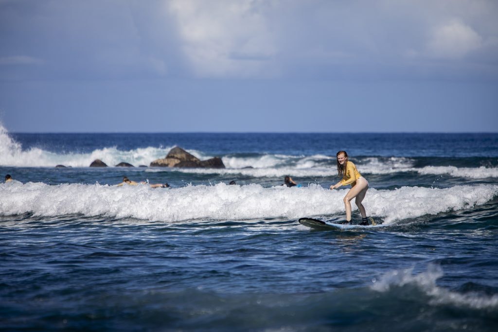 A Rustic Pathways student surfs in Hawaii. Fun facts about Hawaii