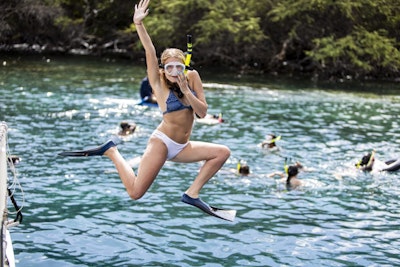 Student jumping into clear blue waters during a summer teen tour to Hawaii.