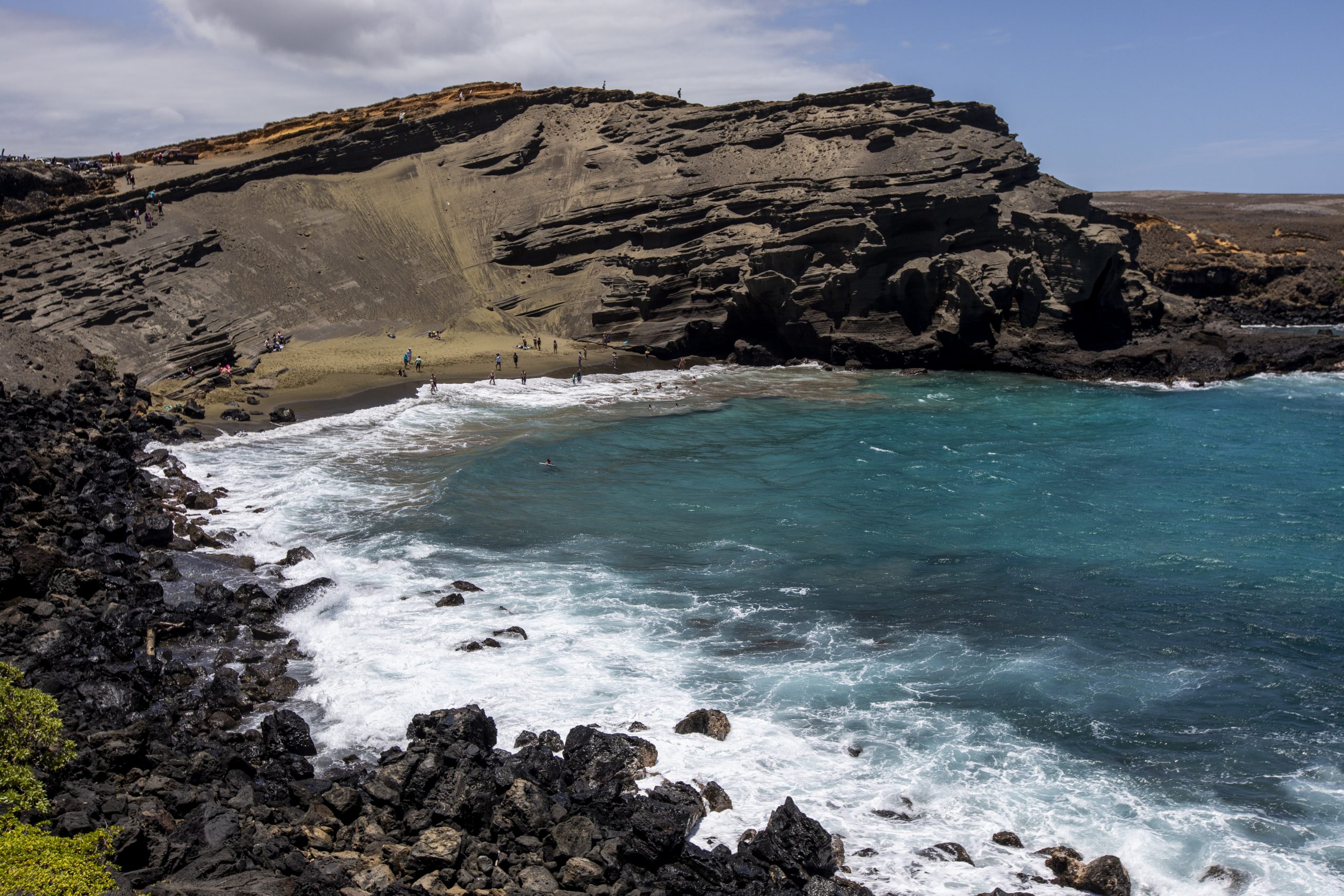 A green-sand cove enclosed by an eroded cinder cone.