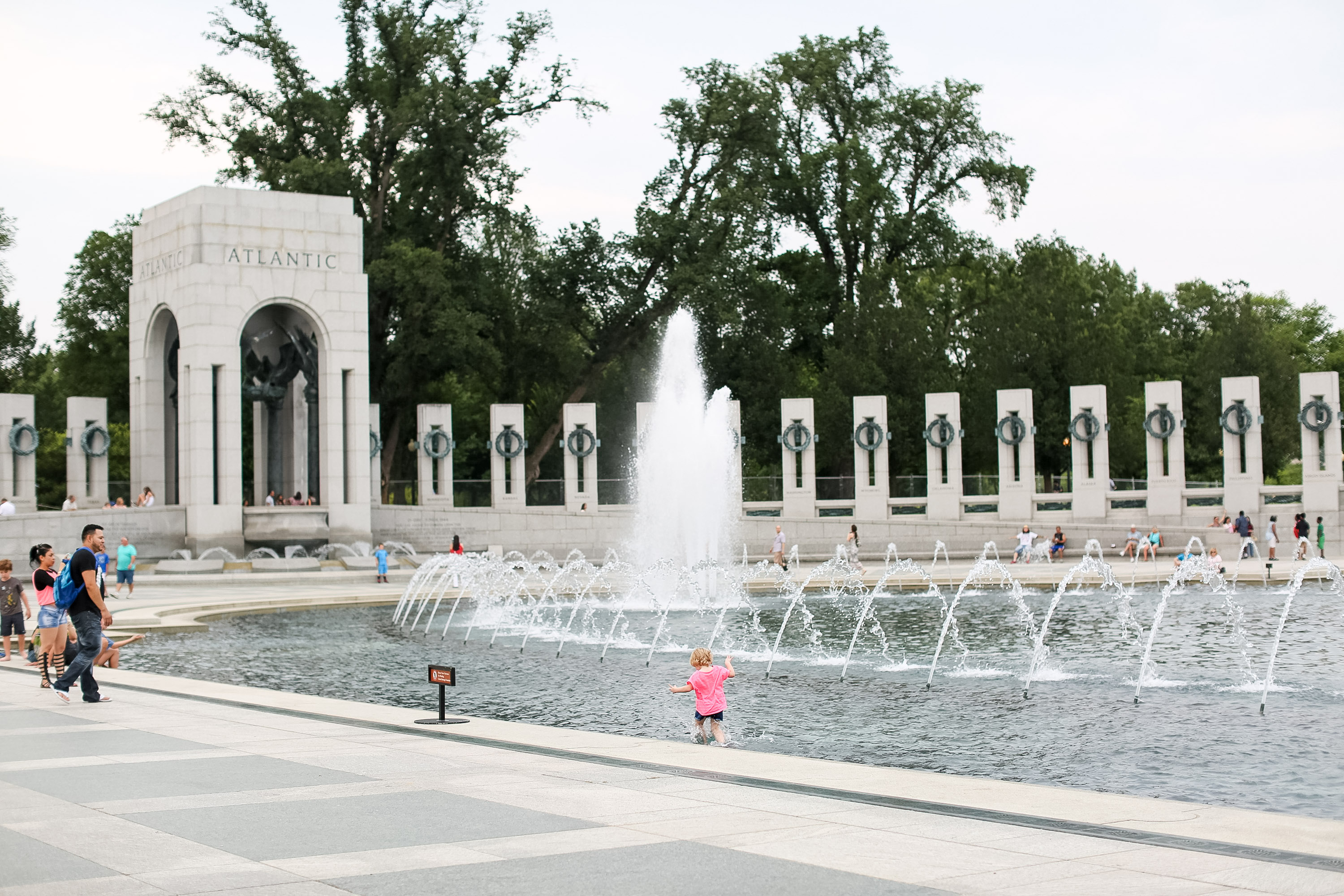 Fountains spray at the National World War II Memorial in the United States, its colonnade curving behind