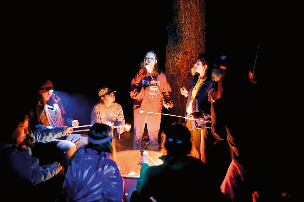 Students enjoy a camp fire with s'mores.