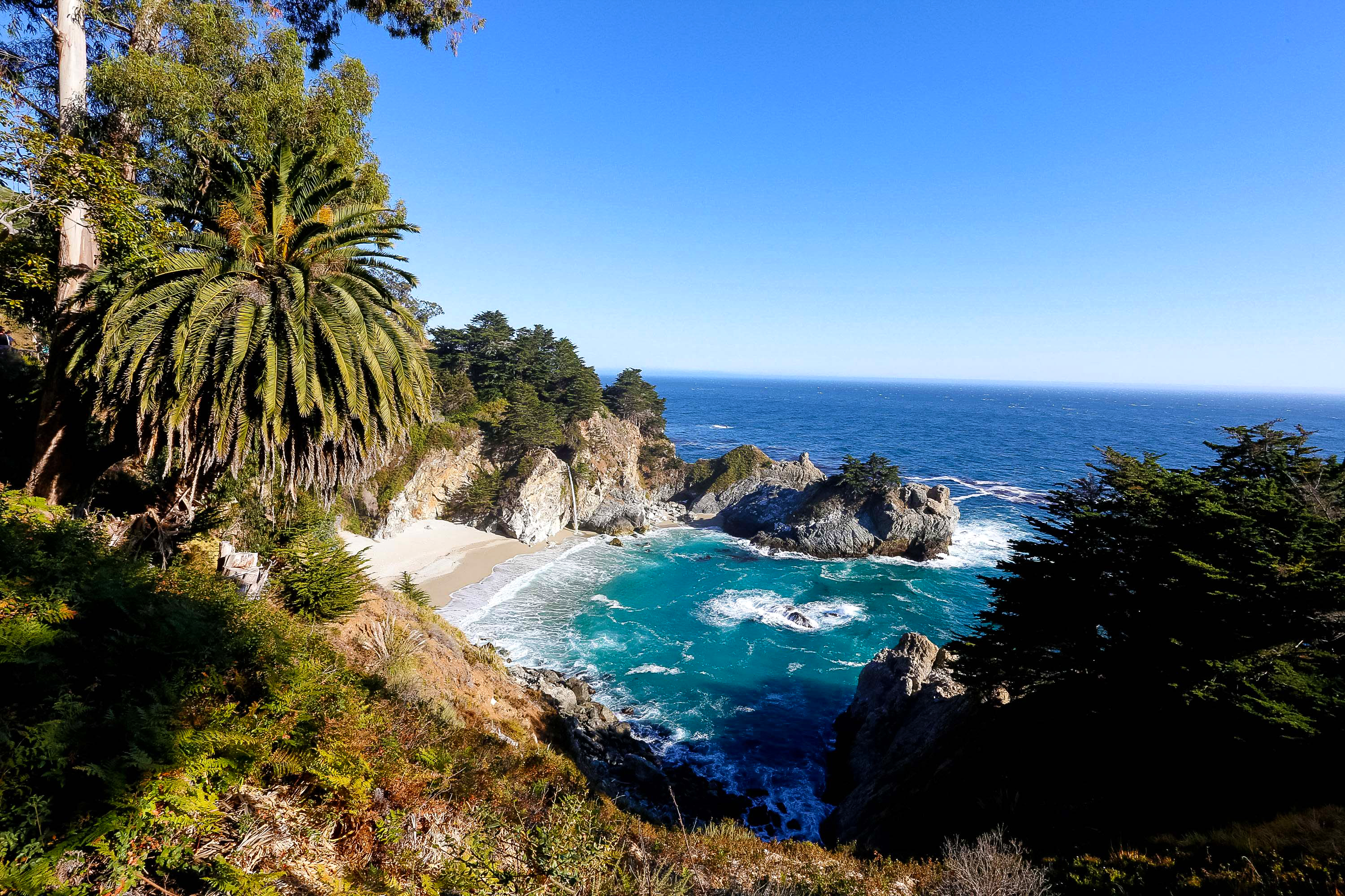 A cove on the Big Sur coast with a waterfall dropping to the beach.