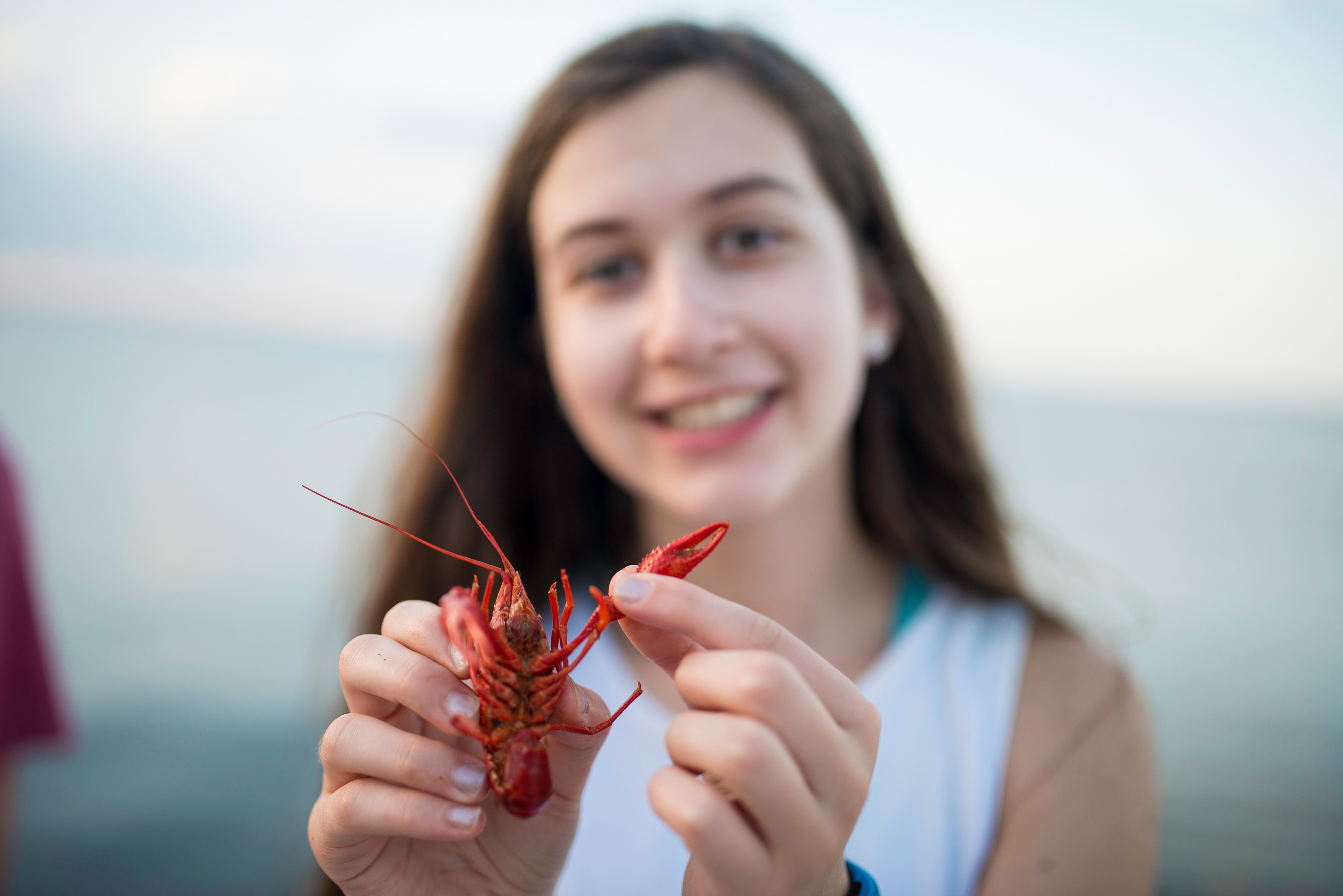 Girl holding a small lobster in New Orleans.