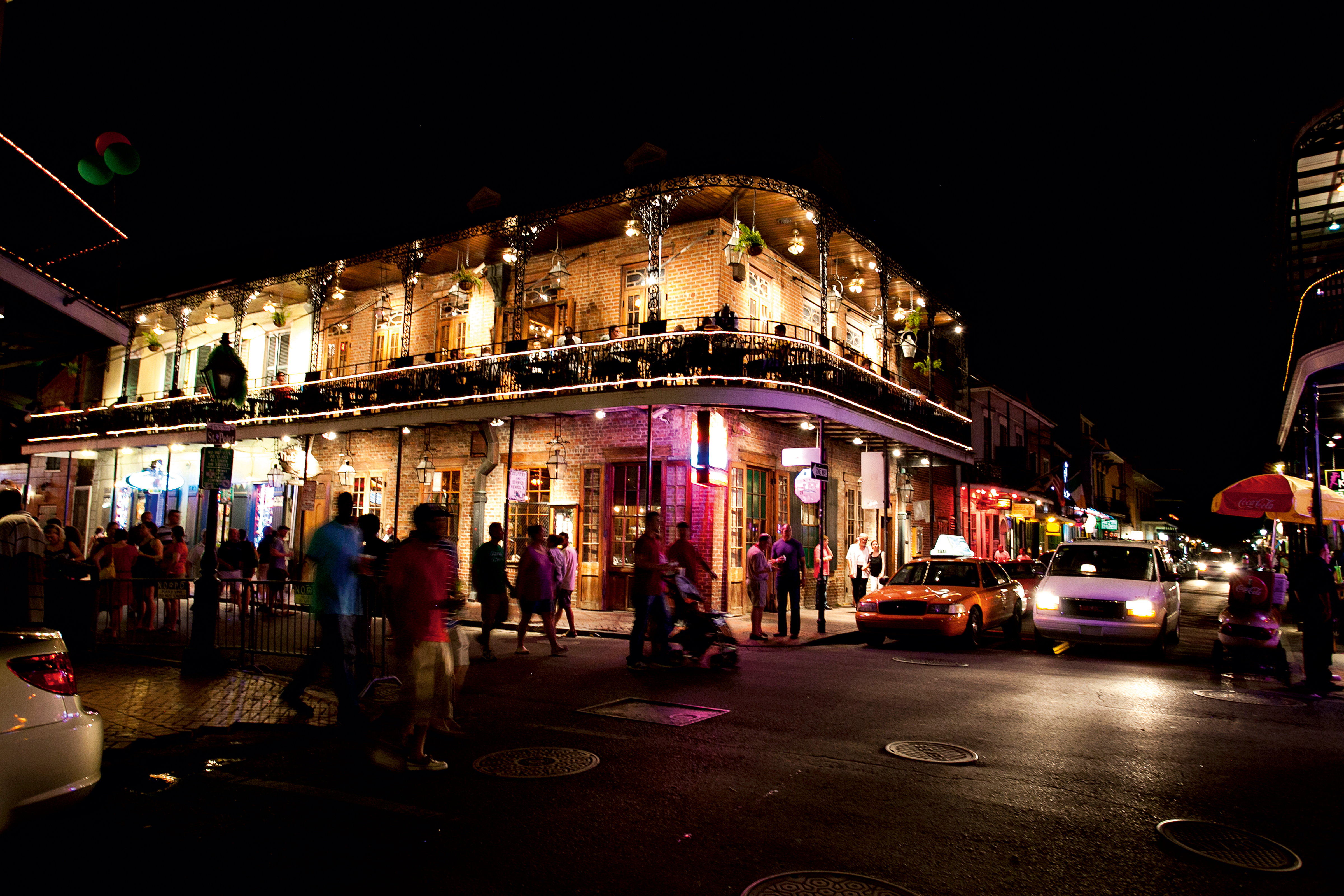 Night life in New Orleans with people walking in the streets and view of lit of building.
