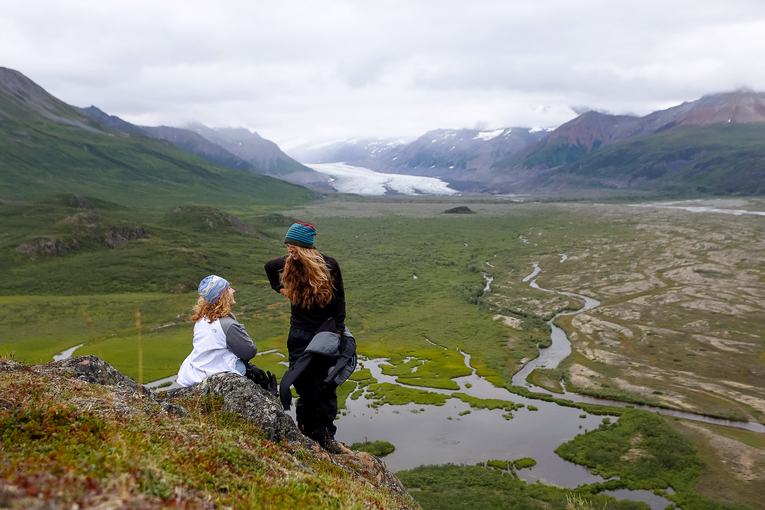 Students look out over a glacial valley from a rocky overlook in Alaska