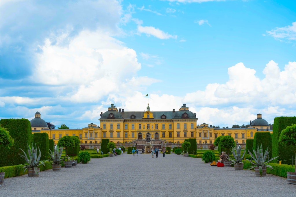 Drottningholm Palace features stunning baroque architecture with intricate details, surrounded by beautifully landscaped gardens.