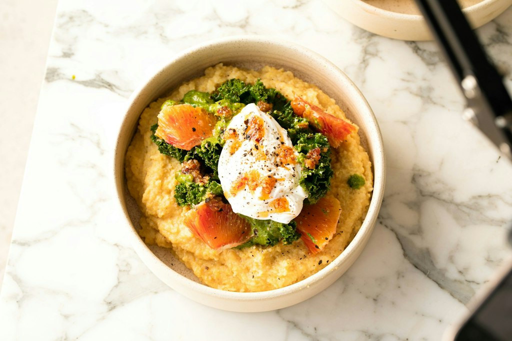Photo by <a href="https://unsplash.com/@bakdandraw?utm_content=creditCopyText&utm_medium=referral&utm_source=unsplash">Bakd&Raw by Karolin Baitinger</a> on <a href="https://unsplash.com/photos/a-bowl-of-food-on-a-marble-table-ffQBGKUzEaU?utm_content=creditCopyText&utm_medium=referral&utm_source=unsplash">Unsplash</a> Italy Polenta (in Italian cuisine)