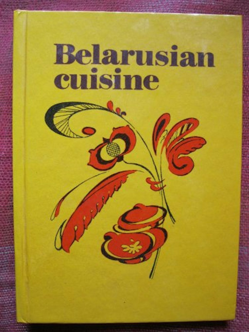 Yellow book titled Belarusian cuisine with drawing of a flower.