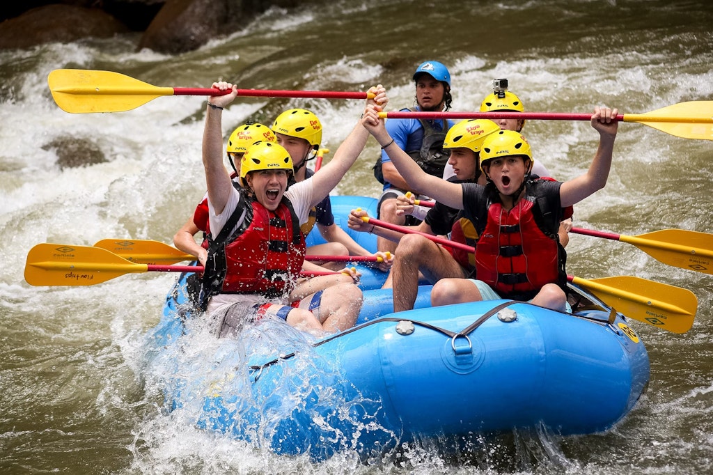 Student travelers enjoying a safe whitewater rafting activity during an outdoor program.