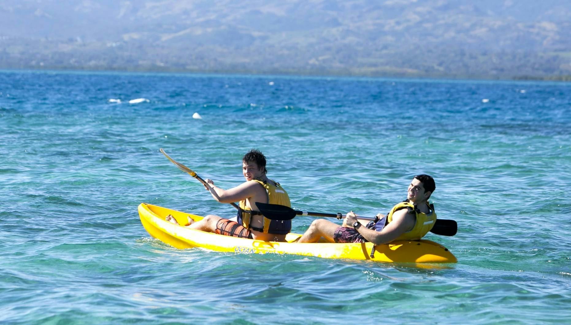 Two students kayaking on a gap year adventure in tropical waters.